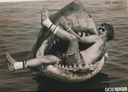 Steven Spielberg sits in the mechanical shark used in JAWS